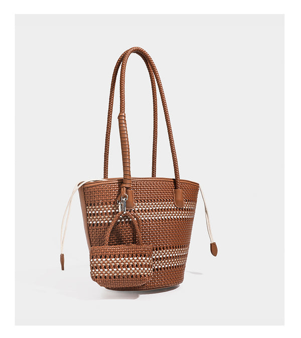 Light blue open-weave woven bucket tote bag with long braided shoulder straps, drawstring side ties, and attached mini pouch