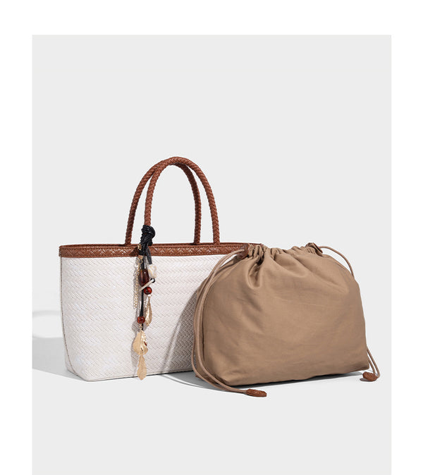 Structured woven-texture tote bag with brown braided top handles, decorative tassel charm, and detachable shoulder strap