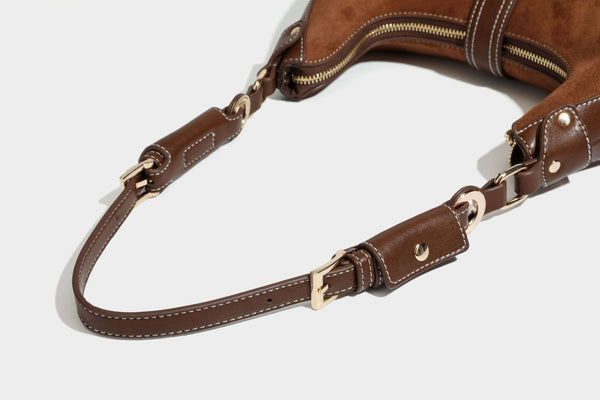 Halbmondförmige Schultertasche in camelbrauner Wildlederoptik mit weißen Kontrastnähten, goldfarbenen Beschlägen und