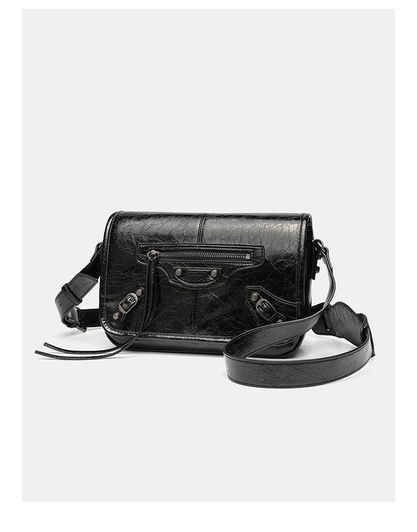 Small structured rectangular crossbody bag with crinkle leather-look finish, front zip pocket, gunmetal stud hardware, and