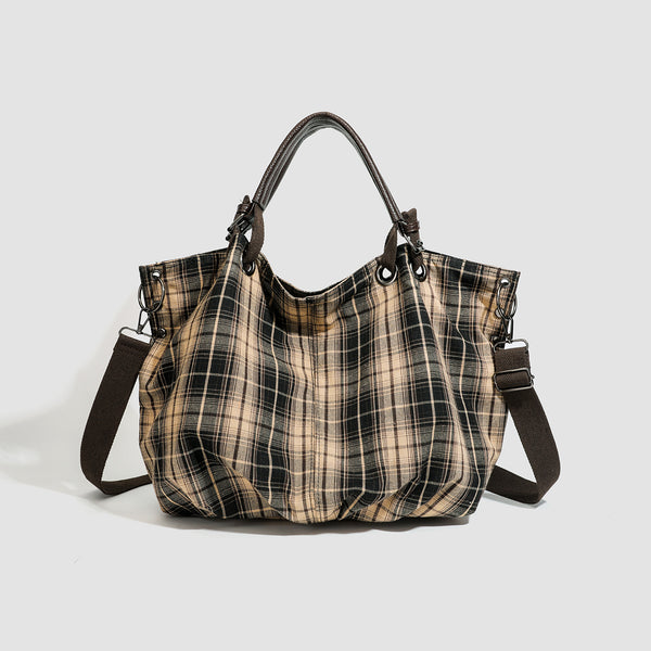 Slouchy matte canvas tote bag with dark dual top handles, metal grommet hardware, and detachable long shoulder strap, detail