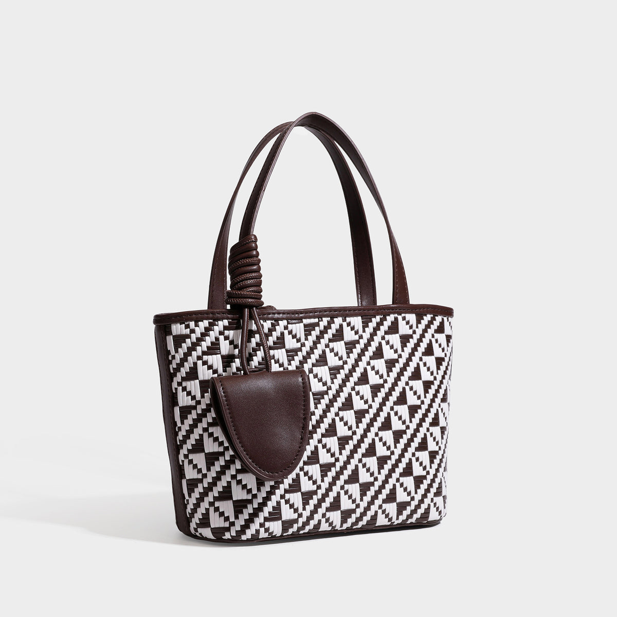 Kleiner, strukturierter Shopper mit gewebtem geometrischem Muster, glatten Besätzen in Lederoptik, geknoteten Henkeln, Reißverschluss und herabhängendem Frontdetail