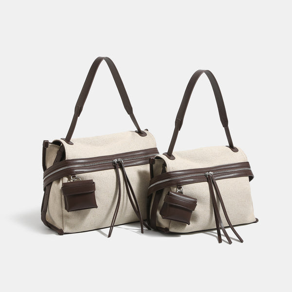 Off-white woven cotton-linen shoulder bag with brown leather-look trim, dual zip closure, long zipper pulls, front exterior