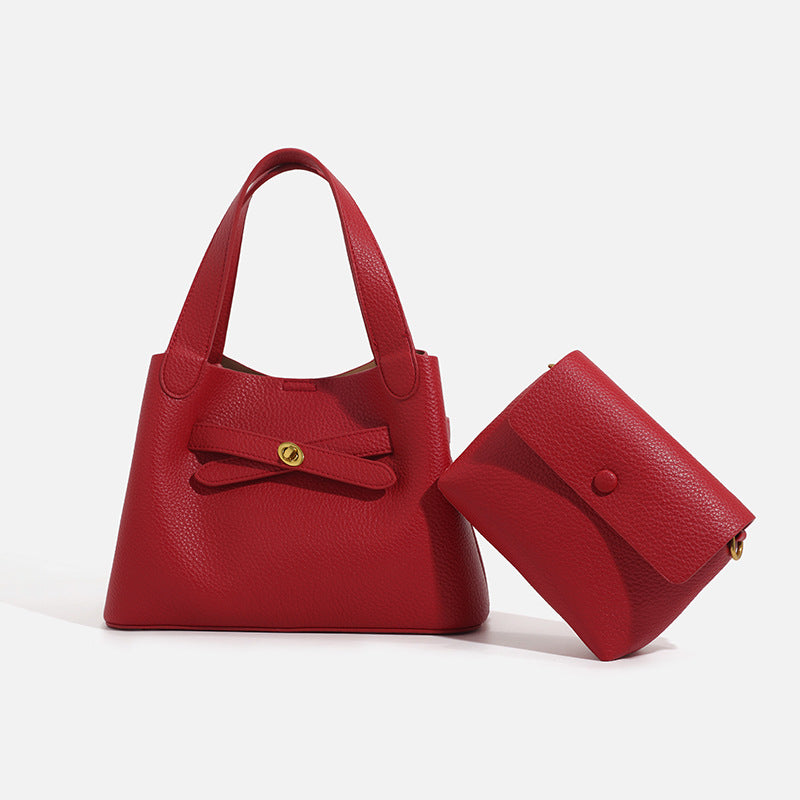 Pebbled trapezoid tote bag with gold turn-lock strap detail and matching snap pouch, front view