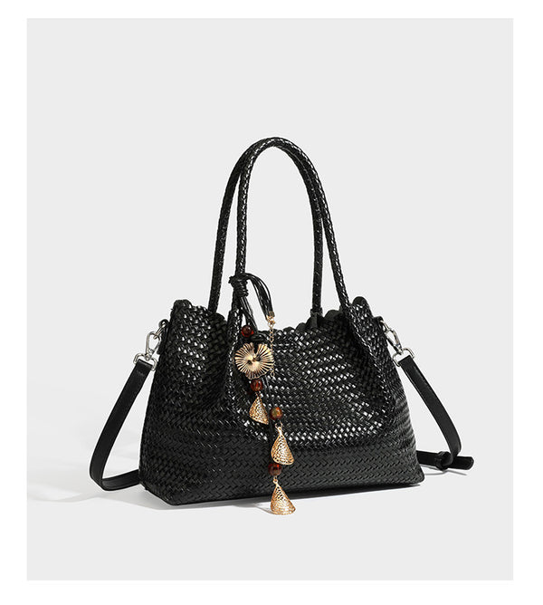 Strukturierter, glänzend geflochtener Shopper mit Muschelkantenabschluss am oberen Rand, geflochtenen Tragegriffen, abnehmbarem Crossbody-Riemen und Perlenquaste