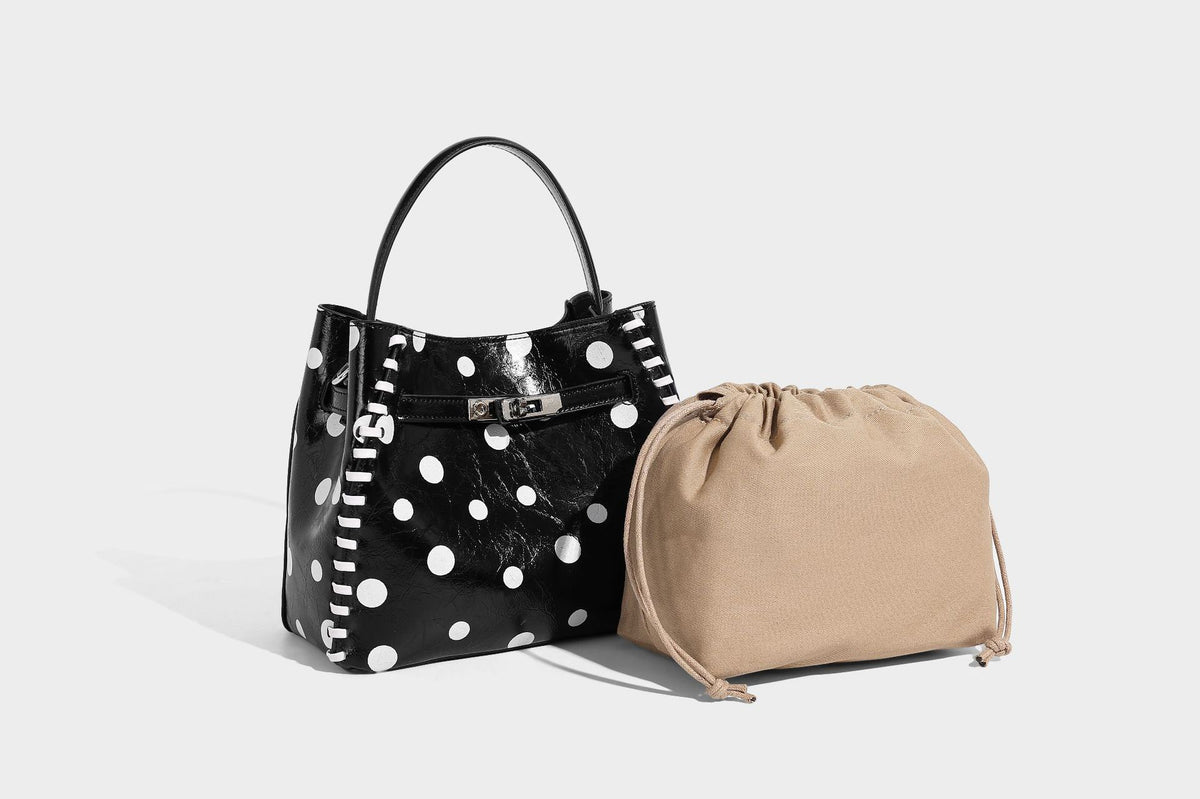 Glänzende, geknautschte Beuteltasche mit Polka-Dots, silberfarbenen Schnallenbeschlägen, kontrastierendem seitlichem Schnürbesatz, Tragegriff und abnehmbarem