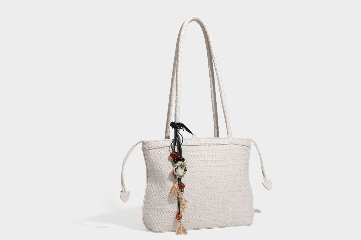 Structured woven leather-look tote bag in dark brown with long shoulder straps, side drawstring ties, and gold filigree