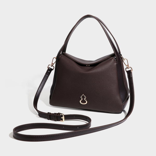 Structured pebbled leather-look shoulder bag with flap top, gold-tone emblem hardware, dual top handles, and detachable