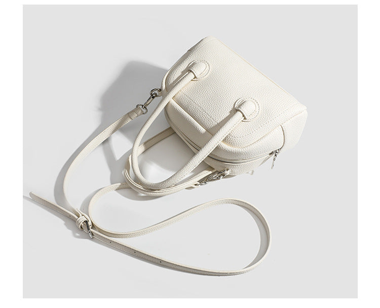 Mini-Boston-Tasche mit genarbtem Finish, zwei Henkeln, abnehmbarem und verstellbarem Crossbody-Riemen sowie silberfarbenen Beschlägen, Detailansicht
