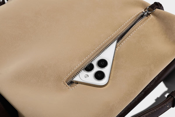 Slouchy hobo tote bag with matte leather-look finish, triangular silhouette, front zip pocket, and adjustable shoulder strap