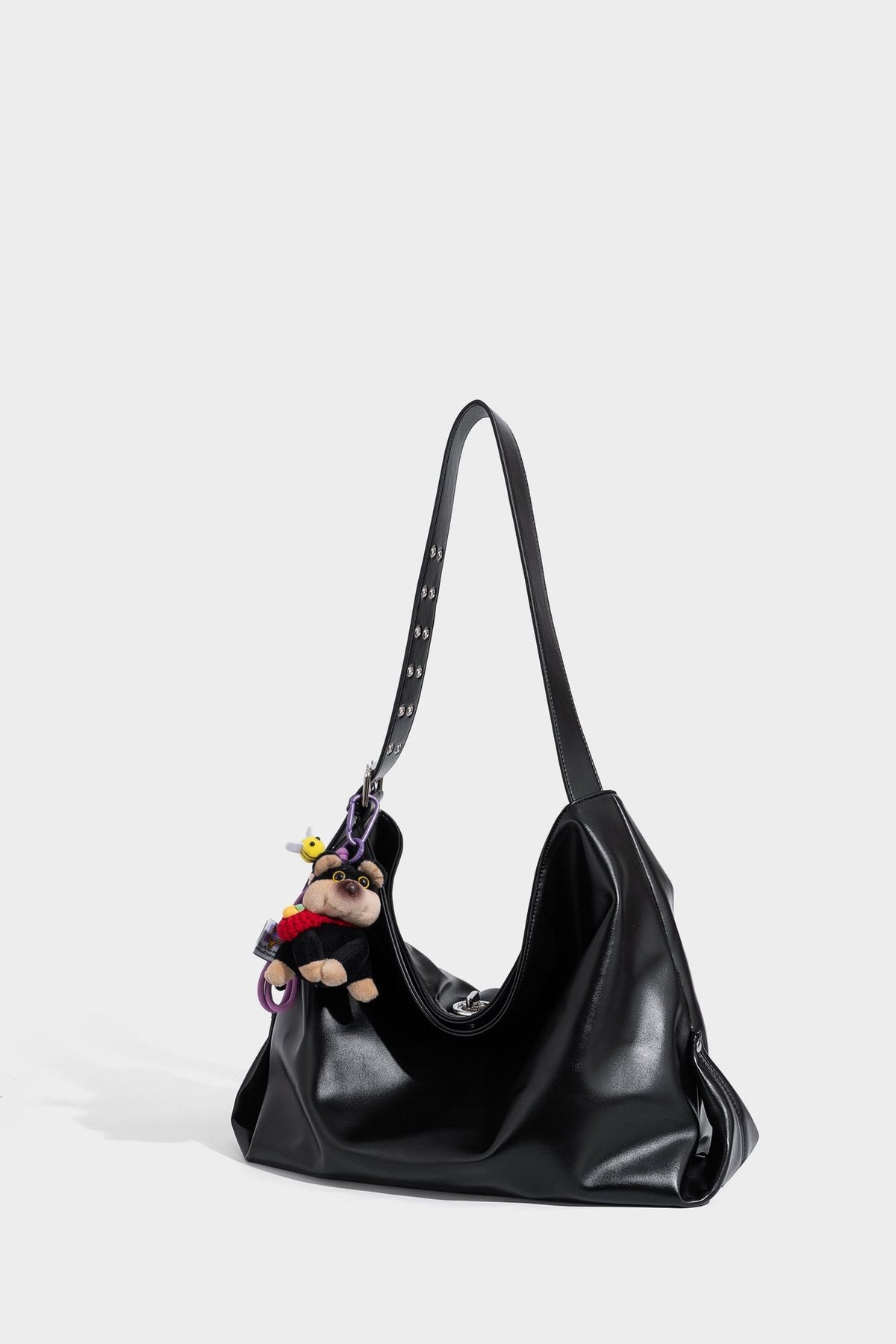 Große schwarze, glänzende Hobo-Schultertasche in Lederoptik mit mit Ösen besetztem Riemen, silberfarbenen Beschlägen und abnehmbarem