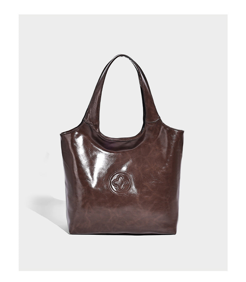 Glossy oil-wax leather-look open-top tote shoulder bag with embossed circular logo and long double straps, detail view 8