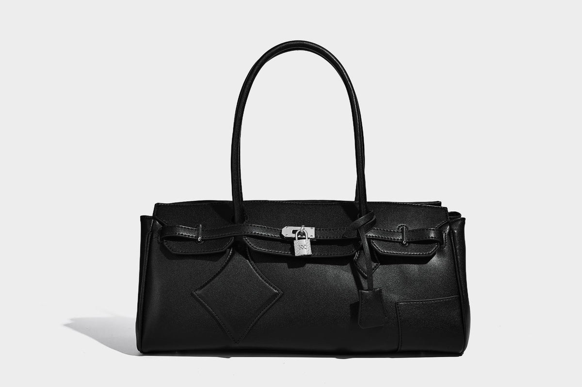 Strukturierte Tote-Bag in schwarzer Lederoptik mit Drehverschluss in Vorhängeschloss-Optik, dekorativen Riemendetails und abgerundeten Doppelhenkeln