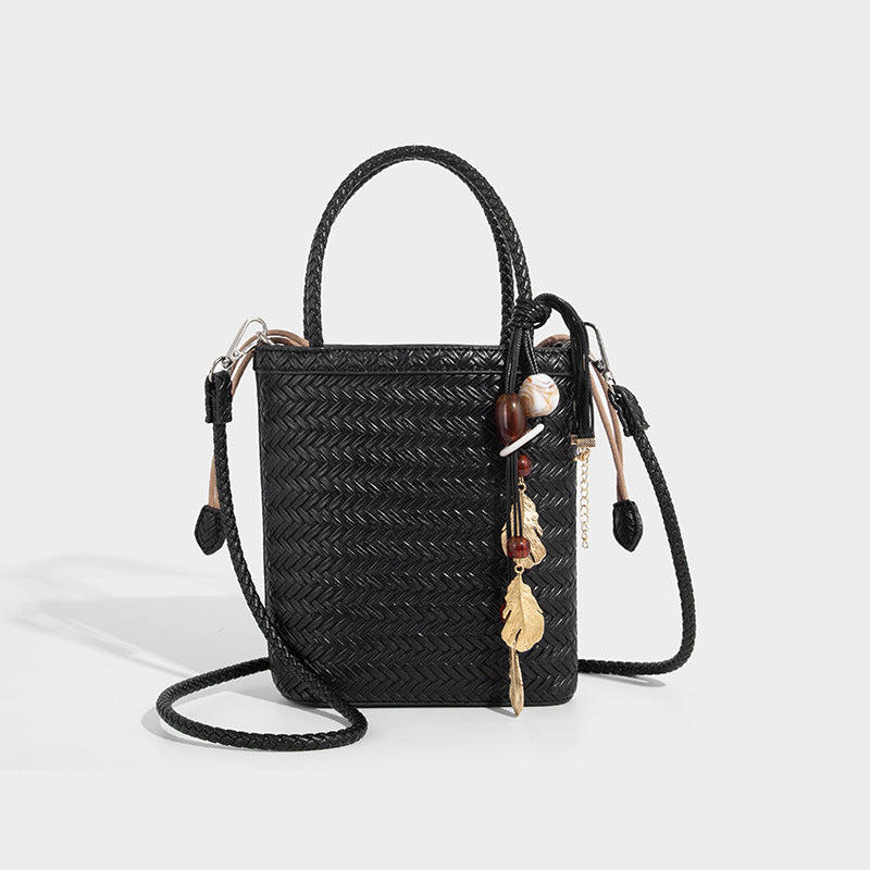 Small structured woven-texture tote bag with braided top handles and drawstring inner pouch, detail view 6