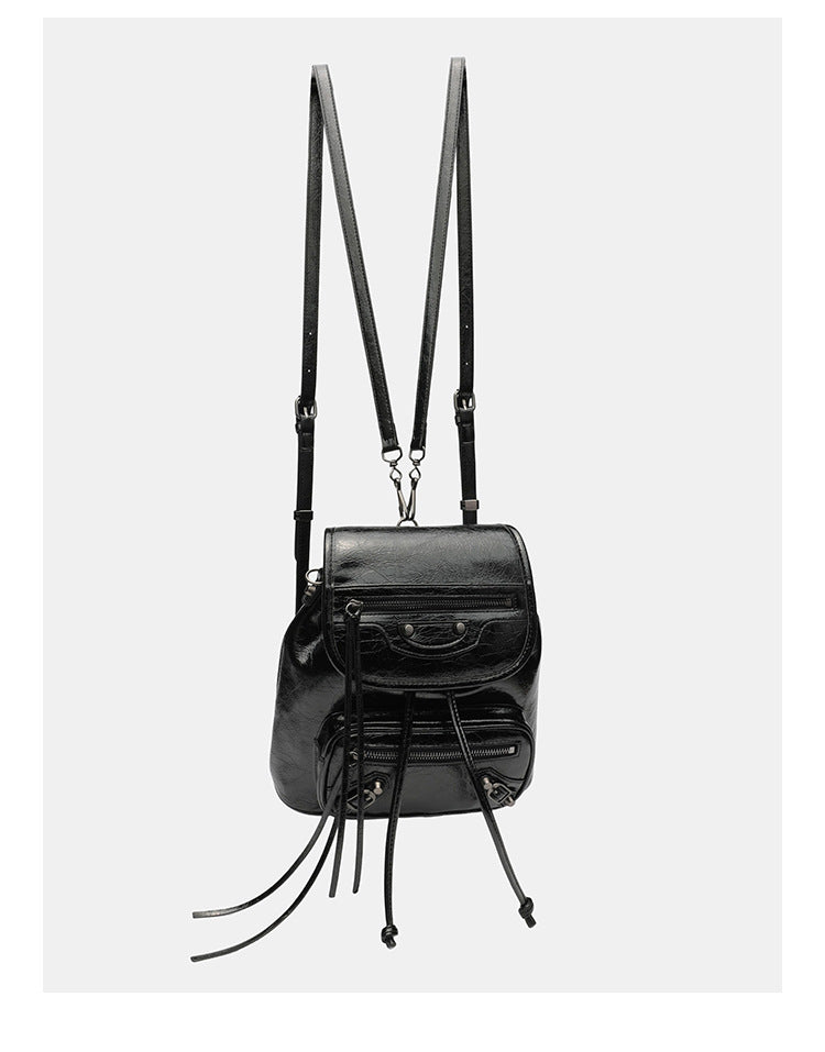 Small structured glossy leather-look convertible backpack handbag in black with flap closure, front zip pockets, metal stud