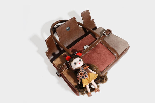 Structured color-block satchel bag in brown, rust, beige, and taupe suede-look panels with white topstitching, front buckle