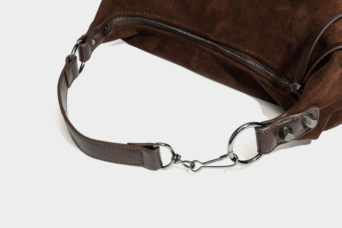 Slouchy suede-finish hobo shoulder bag with dark hardware, exterior zip pocket, tassel ties, and detachable crossbody strap