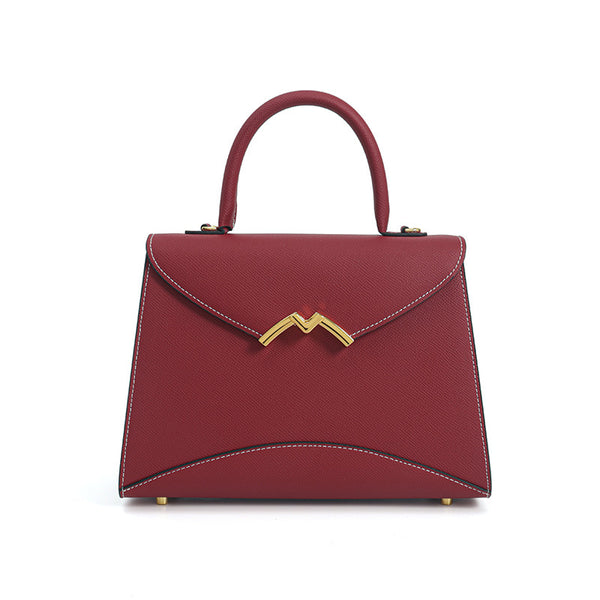 Structured trapezoid top-handle satchel in golden brown cross-grain textured finish with gold M-shaped clasp hardware and