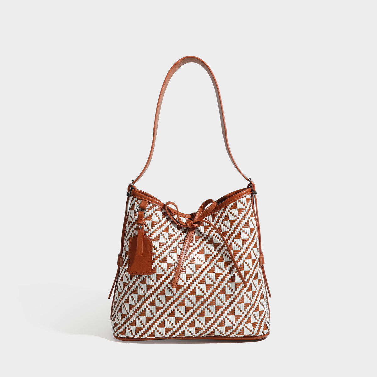 Woven geometric bucket shoulder bag in white and dark brown two-tone pattern with leather-look trim and drawstring top