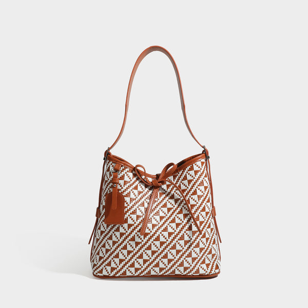 Woven geometric bucket shoulder bag in white and dark brown two-tone pattern with leather-look trim and drawstring top
