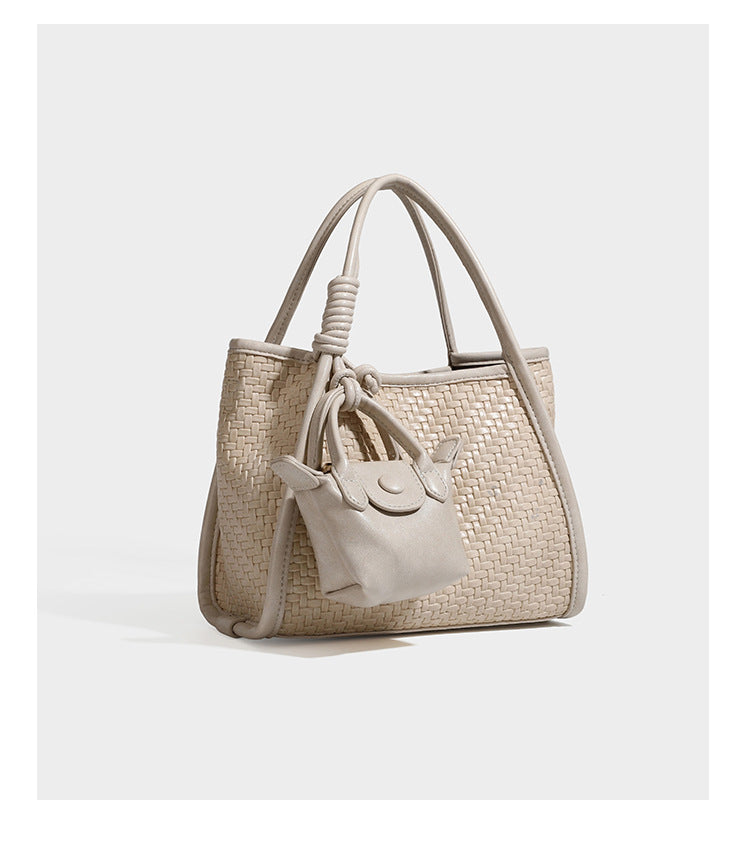 Strukturierte Tote-Bag mit Webstruktur in Braun, glattem, lederähnlichem Besatz, geknoteten Tragegriffen und einer befestigten Mini-Beuteltasche mit Kordelzug