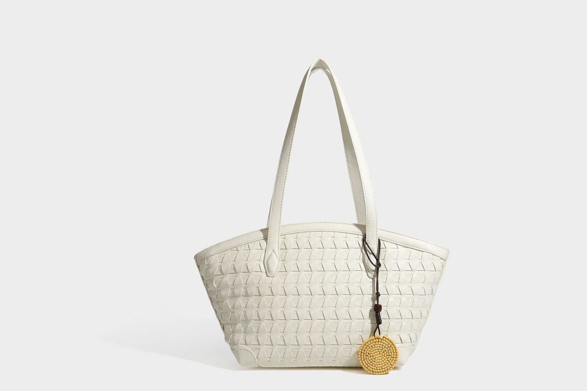 Large leather-look tote bag with geometric woven emboss, double shoulder straps, and round woven cord charm in brown, detail