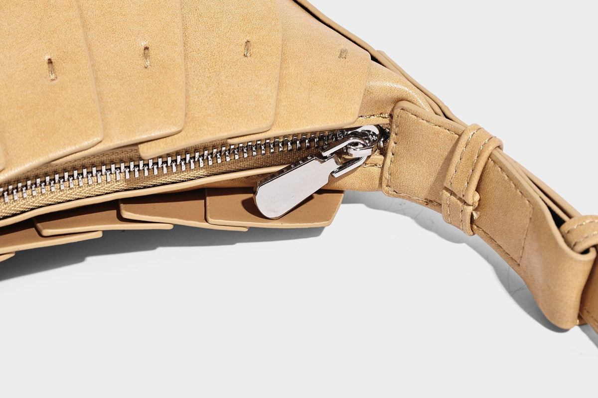Crescent half-moon shoulder bag with vertical panel seaming, matte-satin leather-look finish, and adjustable gold-tone
