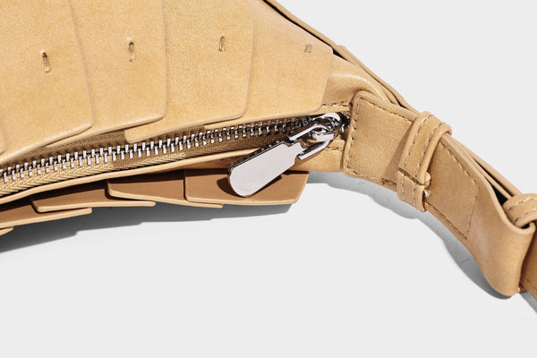 Crescent half-moon shoulder bag with vertical panel seaming, matte-satin leather-look finish, and adjustable gold-tone