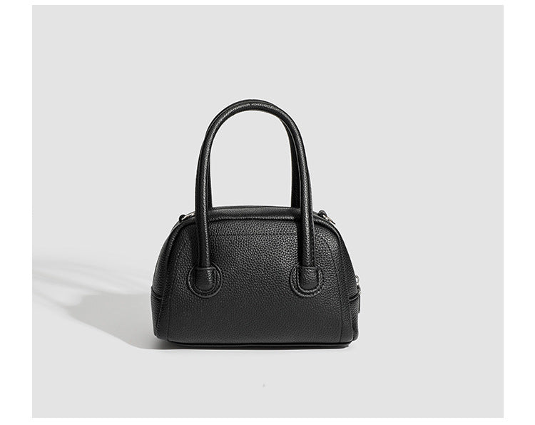 Mini-Boston-Tasche mit genarbtem Finish, zwei Henkeln, abnehmbarem und verstellbarem Crossbody-Riemen sowie silberfarbenen Beschlägen, Detailansicht
