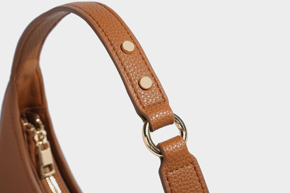Halbmondförmige Hobo-Schultertasche in genarbter Lederoptik mit schmalem Riemen und goldfarbenen Reißverschlussdetails, Detailansicht