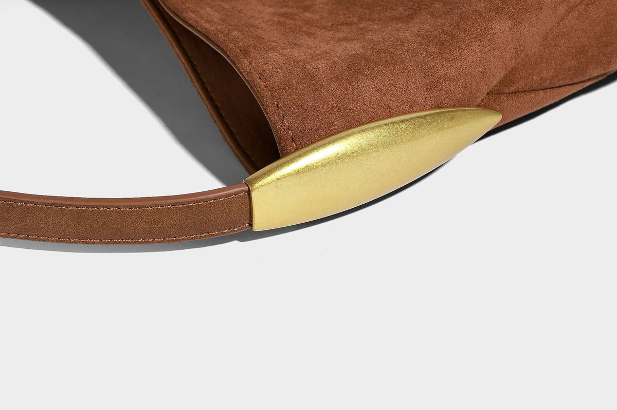 Beige-braune Hobo-Schultertasche mit lässiger Silhouette, matter Veloursleder-Optik, goldfarbenen halbmondförmigen Beschlägen und schmalem Schulterriemen, Detailaufnahme
