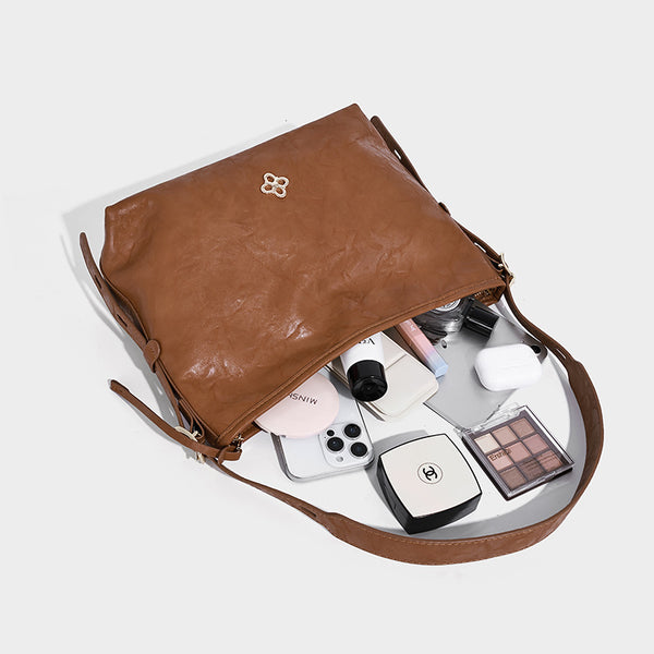 Slouchy leather-look hobo shoulder bag with gold-tone hardware and adjustable strap in brown, detail view 4