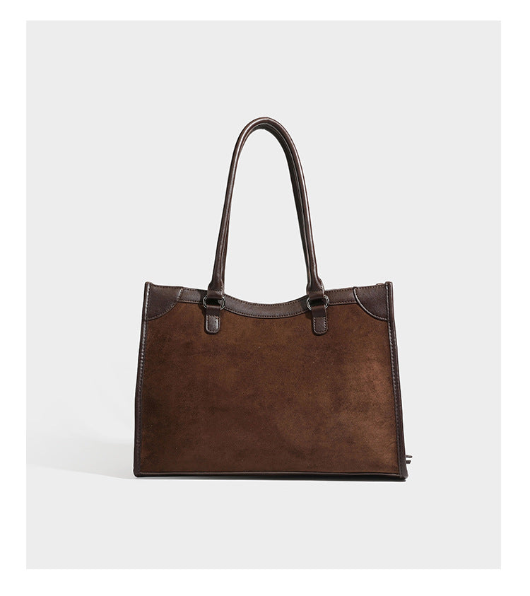 Large structured tote bag with matte suede-like body, smooth leather-look trim, front zip pocket, stud hardware, and