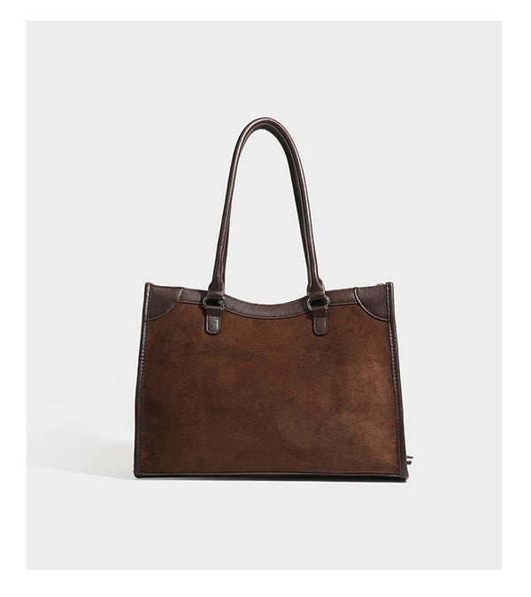 Large structured tote bag with matte suede-like body, smooth leather-look trim, front zip pocket, stud hardware, and