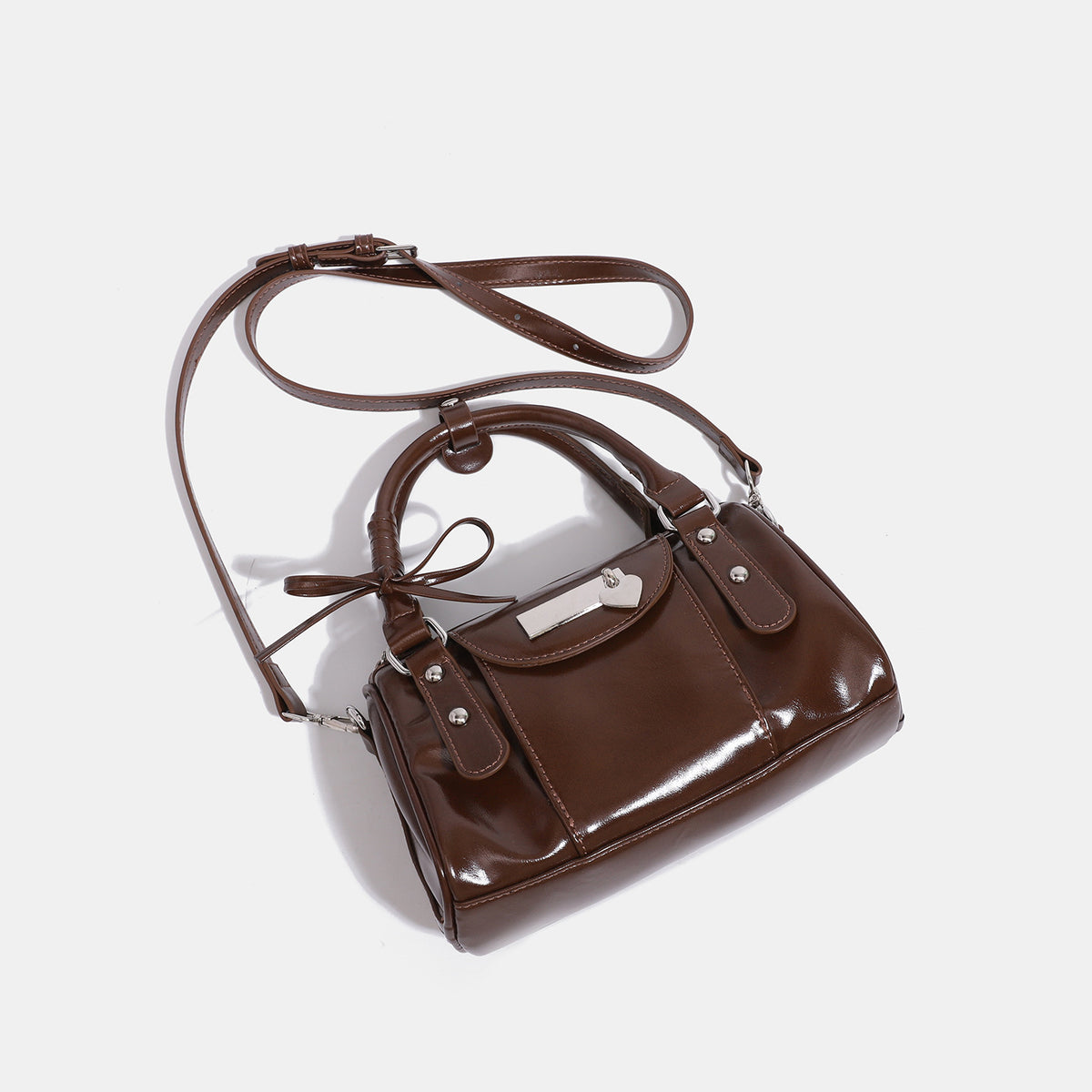 Kleine strukturierte Henkeltasche mit glänzender Oberfläche, zwei Tragegriffen, aufgesetzter Fronttasche, herzförmigem Verschlussanhänger und silberfarbenem