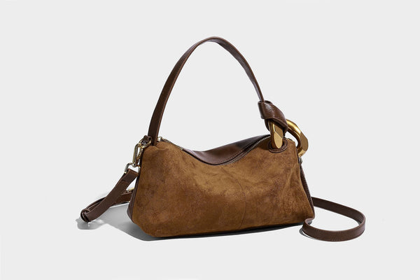Kompakte Boston-Schultertasche in warmer Braunfarbe mit Wildlederoptik, glatten dunkelbraunen Besätzen, übergroßen goldfarbenen Ringbeschlägen und Reißverschluss oben