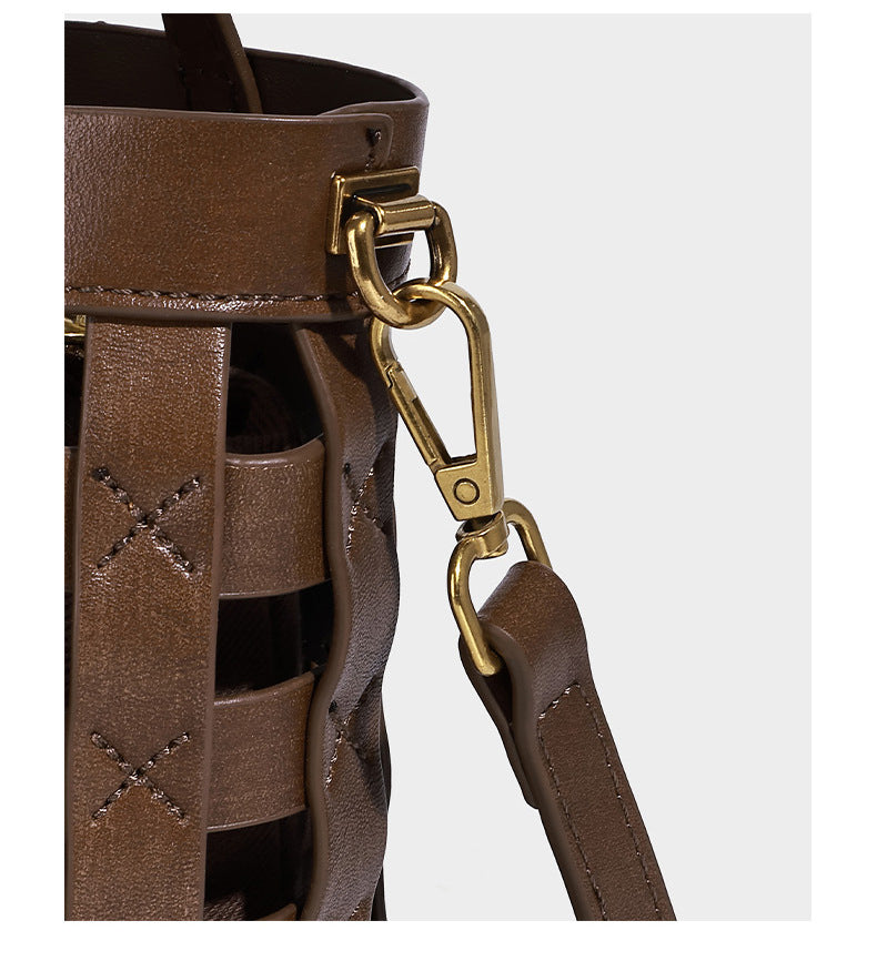 Small woven lattice bucket bag in brown leather-look finish with beaded tassel charm, dual top handles, and detachable