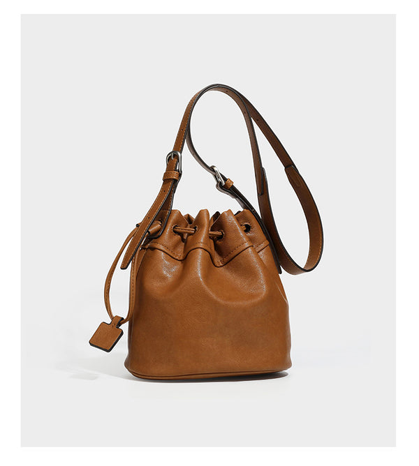 Kleine dunkelbraune Beuteltasche mit Kordelzug, langem verstellbarem Crossbody-Riemen und silberfarbenen Beschlägen, Detailansicht 18