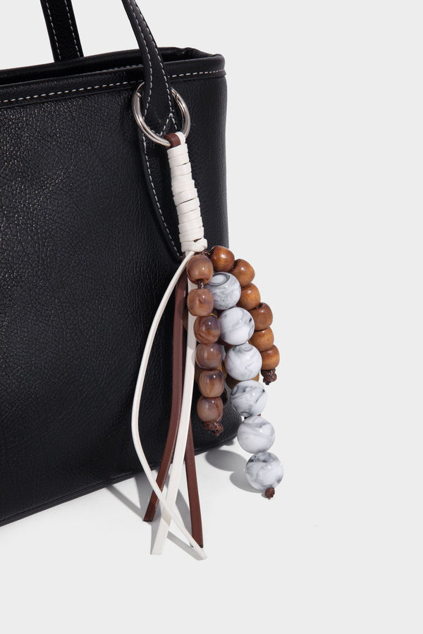 Compact structured bucket tote bag with pebbled textured finish, dual top handles, silver-tone lock hardware, and detachable