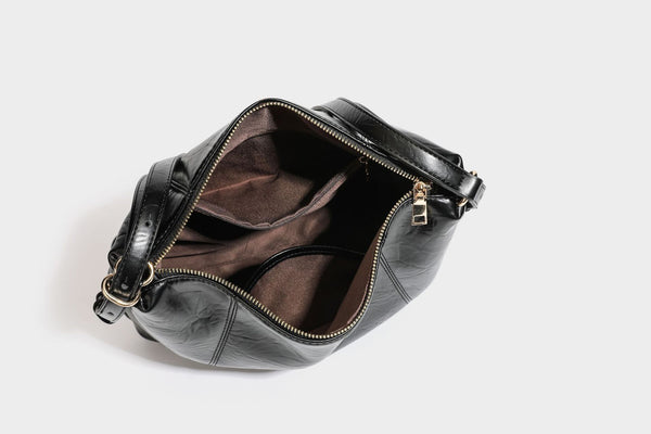 Große, lässig fallende Hobo-Schultertasche in glänzender, geknautschter Lederoptik mit goldfarbenen Beschlägen und langem, verstellbarem Riemen