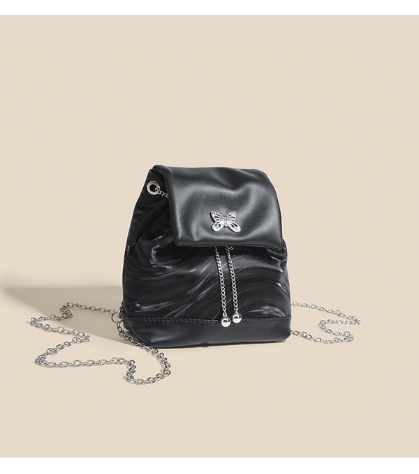 Compact ripple-embossed leather-look backpack handbag with silver butterfly clasp and chain straps, detail view 9