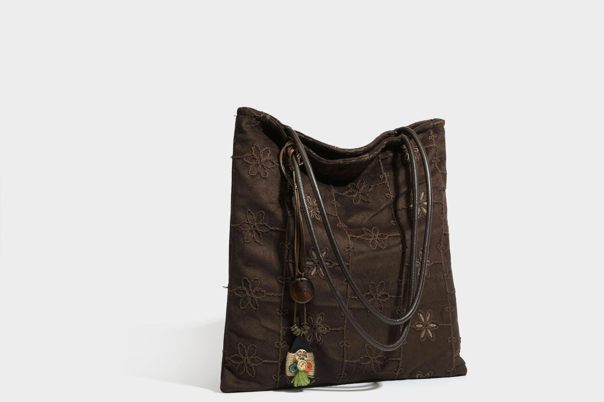 Große, weich fallende Tote-Bag in Dunkelbraun und Wildlederoptik mit Ton-in-Ton-Blumenstickerei im Gittermuster und schmalen Trägern in Lederoptik