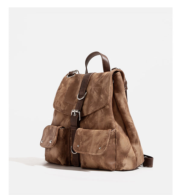 Compact distressed leather-look tan-brown backpack handbag with flap-and-buckle closure, two front patch pockets, top handle