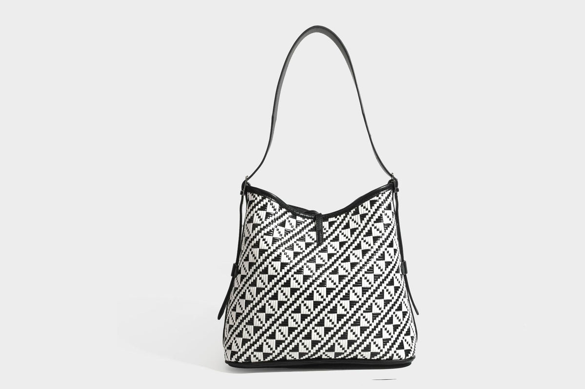 Woven geometric bucket shoulder bag in white and dark brown two-tone pattern with leather-look trim and drawstring top