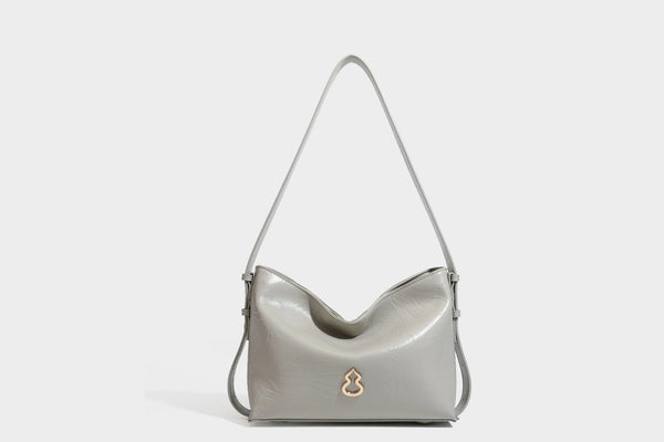 Lässig fallende Hobo-Schultertasche mit offenem Oberteil aus glänzender, karamellbrauner Lederoptik, mit Logo-Beschlägen in Goldoptik und langem, verstellbarem