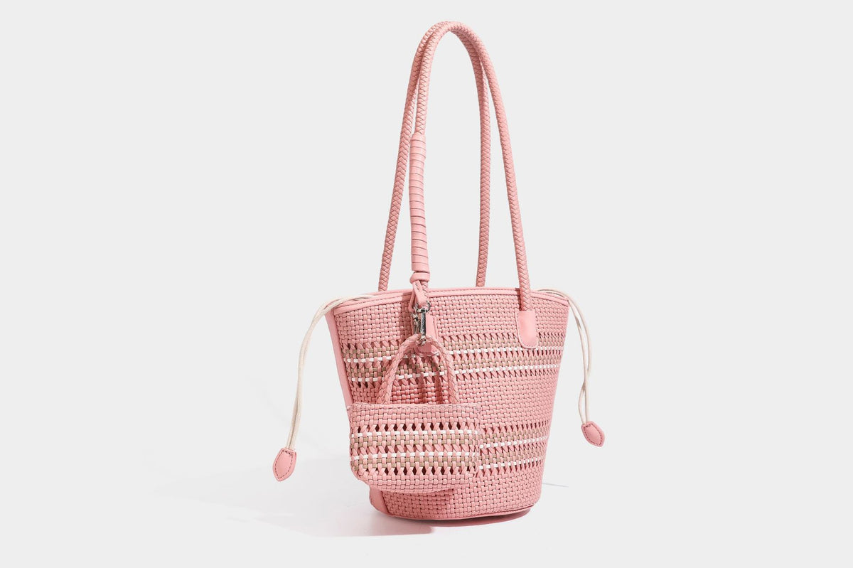Light blue open-weave woven bucket tote bag with long braided shoulder straps, drawstring side ties, and attached mini pouch