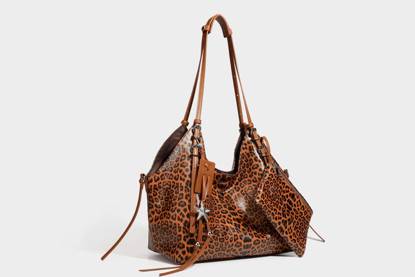 Large leopard print shoulder tote bag with glossy finish, long double straps, front zip pocket, silver-tone hardware, and