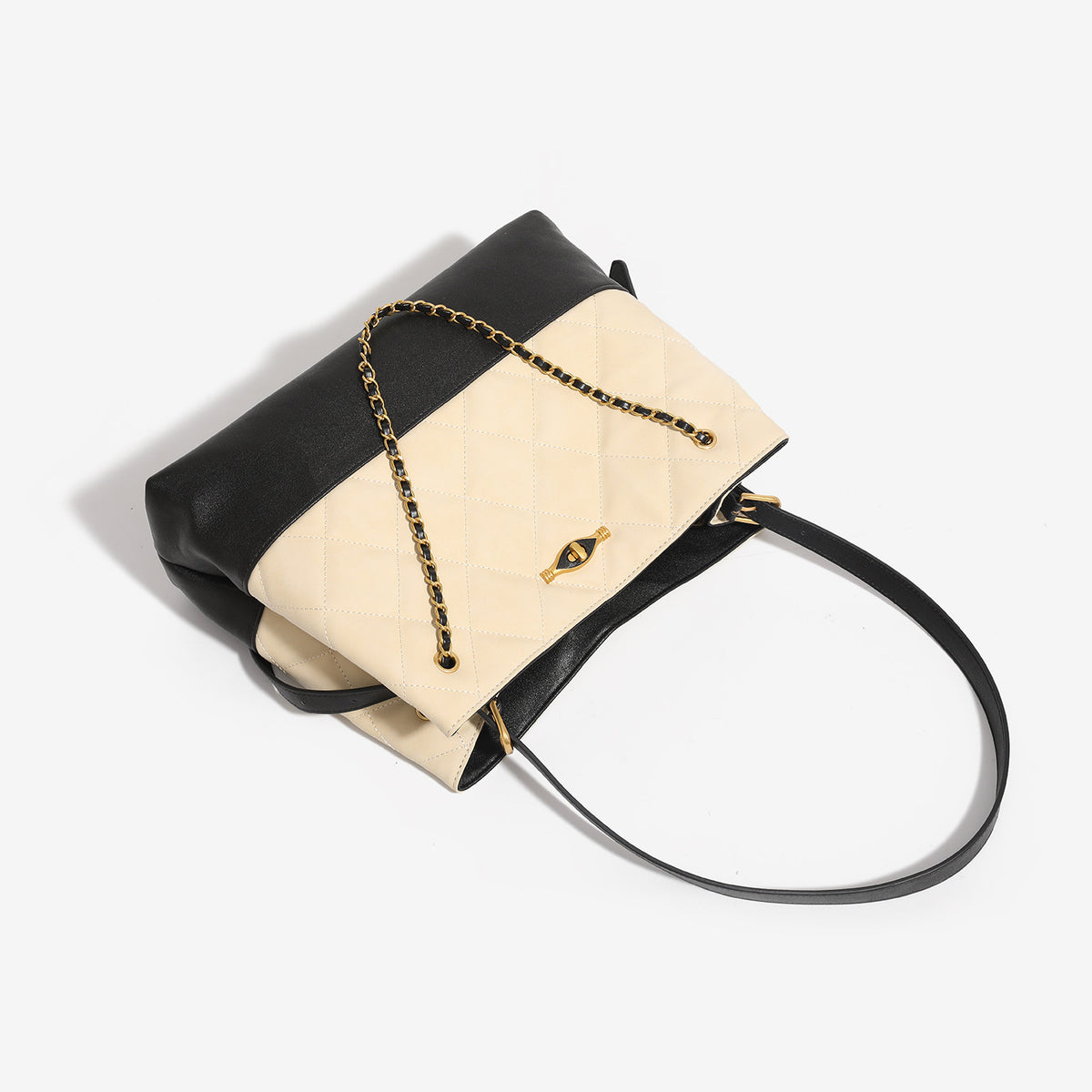 Large quilted two-tone shoulder tote bag with gold-tone chain handles and eye-shaped clasp hardware, detail view 4