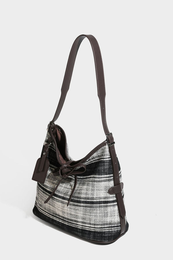 Schwarz-weiß karierte Hobo-Schultertasche aus gewebtem Material mit dunkelbrauner Einfassung in Lederoptik, Kordelzugverschluss und langem, verstellbarem