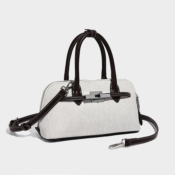 Strukturierte Boston-Tasche aus Stoff in Denimoptik mit schwarzem Besatz in Lederoptik, silberfarbenem Drehverschluss und verknotetem Grün
